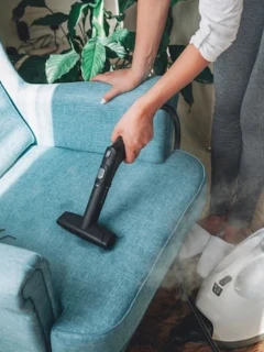 hand-cleaning-armchair-with-steam-cleaner_266247-790